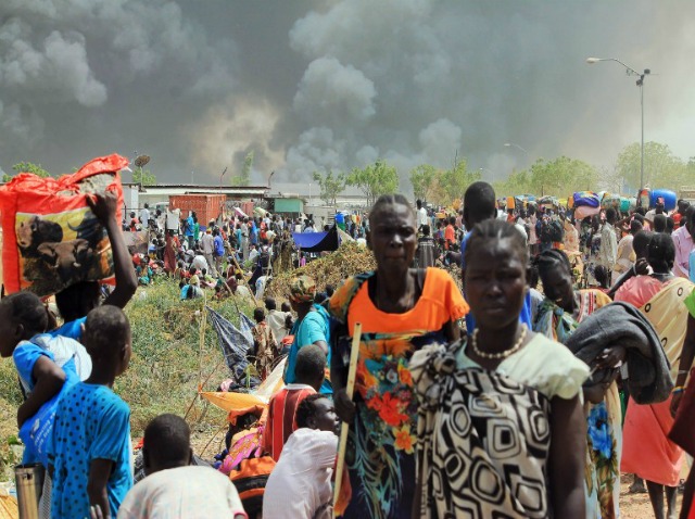 civiles del sur de Sudán huyen de los combates en la ciudad nororiental de Malakal el 18 de febrero de 2016, donde hombres armados abrieron fuego contra civiles refugiados dentro de una base de las Naciones Unidas, matando al menos a cinco personas, el último de una serie de atrocidades en la nación devastada por la guerra, dijo la ONU. Un tiroteo estalló en la base en Malakal en el noreste región del Alto Nilo el 17 de febrero, el año 2016 la noche, con continuos enfrentamientos el jueves por la mañana que dejó grandes penachos de humo de la quema de tiendas de campaña en el campamento que alberga a más de 47.000 civiles. Justin LYNCH / AFP