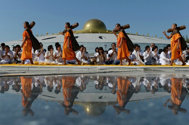 Los monjes budistas del movimiento Dhammakaya polémico llevan sus tiendas de campaña ya que se dispuso en una marcha continua en una cama de pétalos de flores en el templo Dhammakaya en Bangkok el 2 de enero de 2016. AFP PHOTO / Christophe ARCHAMBAULT CHRISTOPHE ARCHAMBAULT / AFP