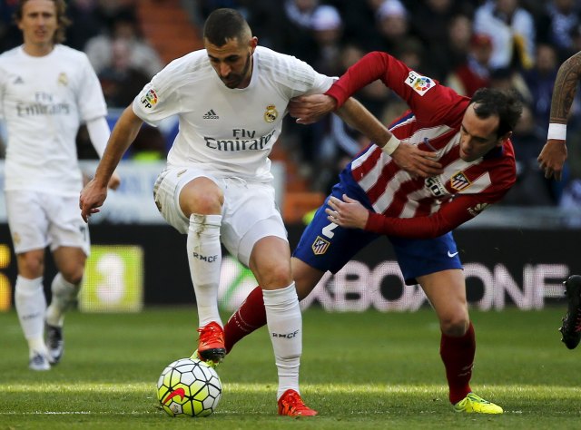 Football Soccer - Real Madrid v Atletico Madrid - Spanish Liga BBVA - Santiago Bernabeu stadium, Madrid, Spain - 27/2/16 Real Madrid's Karim Benzema and Atletico Madrid's Diego Godin in action. REUTERS/Sergio Perez