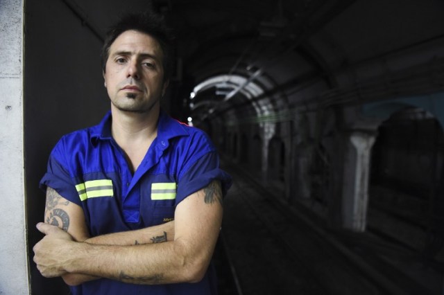 Argentine writer Enrique "Kike" Ferrari poses in a subway station in Buenos Aires, Argentina, on March 14, 2016. Ferrari is an award-winning writer who makes his living cleaning a metro station in Argentina. His noir novels were translated into four languages in six countries, and received awards in Spain and Cuba. AFP PHOTO/EITAN ABRAMOVICH / AFP / EITAN ABRAMOVICH