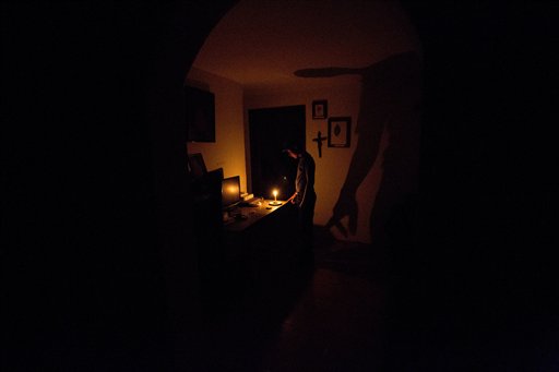 En esta imagen del sábado 23 de abril de 2016, un chico ilumina su casa con velas durante un apagón de 24 horas en el varrio de El Calvario, en El Hatillo, a las afueras de Caracas, Venezuela. El racionamiento eléctrico se sumó a las penurias que afrontan los venezolanos, abrumados por la inflación, la escasex de alimentos y medicinas y una creciente delincuencia. (AP Foto/Fernando Llano)