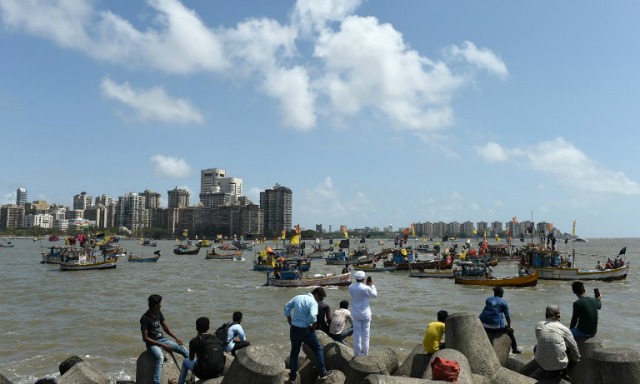 turistas indios toman fotografías como los barcos de pesca y las tripulaciones participan en una 'Mar-Rally' para protestar contra la construcción de Chhatrapati Shivaji El Memorial en el Mar Arábigo frente a la costa de Mumbai el 25 de mayo de 2016. Unos 100 barcos de pesca y los pescadores participado en este rally para poner de relieve las condiciones que van a surgir después de la construcción del memorial mar propuesto para el legendario guerrero Shivaji que puede causar efectos adversos para el sustento de los pescadores. INDRANIL MUKHERJEE / AFP