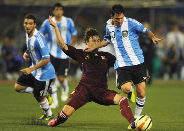 Argentine footballer Lionel Messi (R) tries to take the ball from Venezuelan Ternando Amorebita (C) during a football match in Kolkata on September 2, 2011. Argentina's football team, lead by the newly elected captain Lionel Messi, is playing against Venezuela in the first ever FIFA Friendly International Match on the Indian subcontinent. AFP PHOTO/ Dibyangshu SARKAR (Photo credit should read DIBYANGSHU SARKAR/AFP/Getty Images)