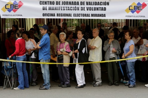 Personas hacen fila afuera de una escuela durante la segunda fase de verificación de firmas para convocar a un referendo revocatorio contra el presidente Nicolás Maduro, en Caracas, Venezuela. 20 de junio de 2016. Miles de venezolanos hacían enormes filas el lunes en colegios, estadios, bibliotecas, plazas y sedes del árbitro electoral para validar las firmas que suscribieron para pedir la activación de un referendo revocatorio del mandato del presidente Nicolás Maduro. REUTERS/Marco Bello