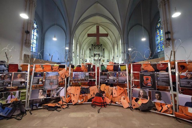 Una exposición llamada "una pared de chalecos salvavidas y sus historias" de los artistas Andrew Wakeford y Fred George se exhibe en la iglesia de San Juan en Saarbrücken, Alemania, hoy, 14 de julio de 2016. La obra está compuesta de chalecos salvavidas originales encontrados en las playas de Grecia y alambres de espino, además de contar también con entrevistas y retratos de refugiados que han llegado a Europa desde Oriente Medio. La exposición permanecerá abierta hasta el 26 de agosto. EFE/Oliver Dietze