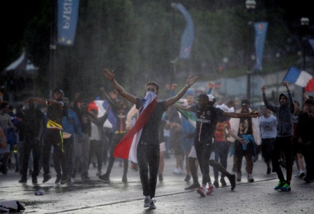 Men clash with French riot policemen after attempting to enter the fan zone of the Champs de Mars next to the Eiffel tower in Paris on July 10, 2016 during the Euro 2016 football tournament final match between Portugal and France. / AFP PHOTO / ALAIN JOCARD