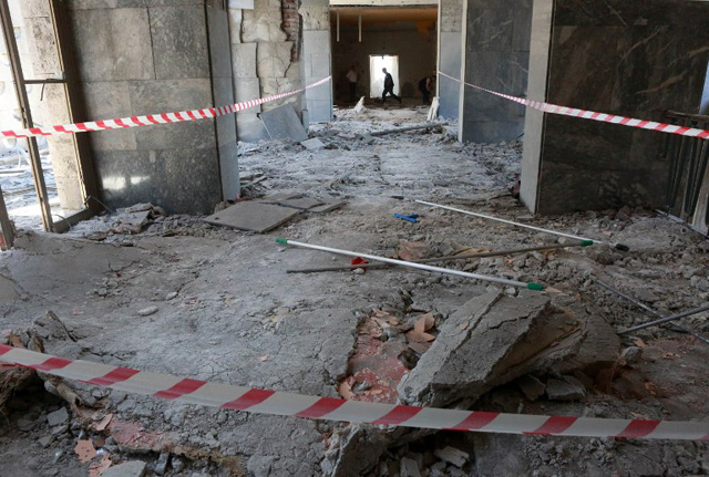 A man walks through rubble after the Grand National Assembly of Turkey was bombed by rebel jets, on July 16, 2016 in Ankara. July 15 putsch bid began with rebel F-16 jets screaming low over rooftops in Ankara, soldiers and tanks taking to the streets and multiple explosions throughout the night in the capital as well as the biggest city Istanbul. With at least 2,839 soldiers already detained in a relentless round-up over the coup plot, the authorities blamed the conspiracy on Erdogan's arch enemy, the US-based cleric Fethullah Gulen. / AFP PHOTO / ADEM ALTAN