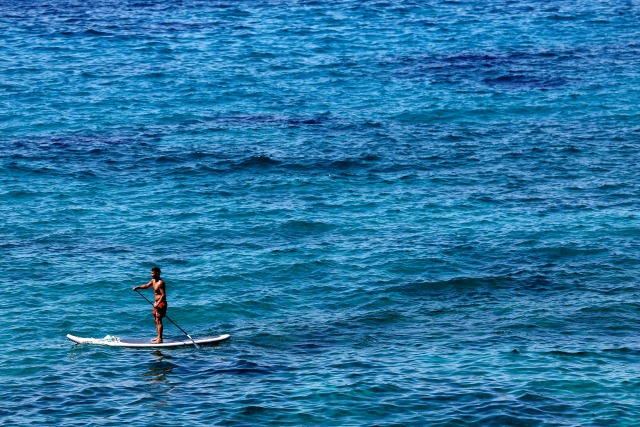 Un hombre paletas en un tablero de pie en el mar Mediterráneo, cerca de Marsella ya que las temperaturas del verano golpean Francia, 20 de julio de 2016. REUTERS / Philippe Laurenson