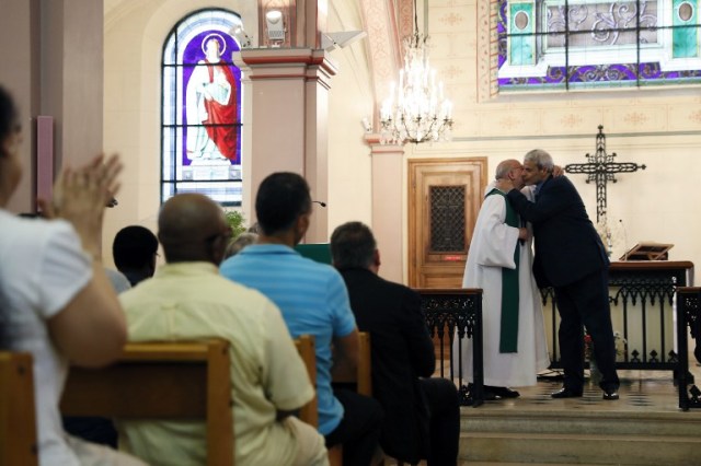 Bagnolet's priest Patrick Morvan (L) embraces Bagnolet's Mosque's rector Mohamed Rakkaby (R) after pronouncing a speech to Christian and Muslim believers during a Mass in tribute to priest Jacques Hamel at the Saint-Leu ? Saint-Gilles Bagnolet's Church, near Paris, on July 31, 2016. Muslims across France were invited to participate in Catholic ceremonies today to mourn a priest whose murder by jihadist teenagers sparked fears of religious tension. Masses will be celebrated across the country in honour of octogenarian Father Jacques Hamel, whose throat was cut in his church on July 26, 2016 in the latest jihadist attack on France. / AFP PHOTO / Thomas SAMSON