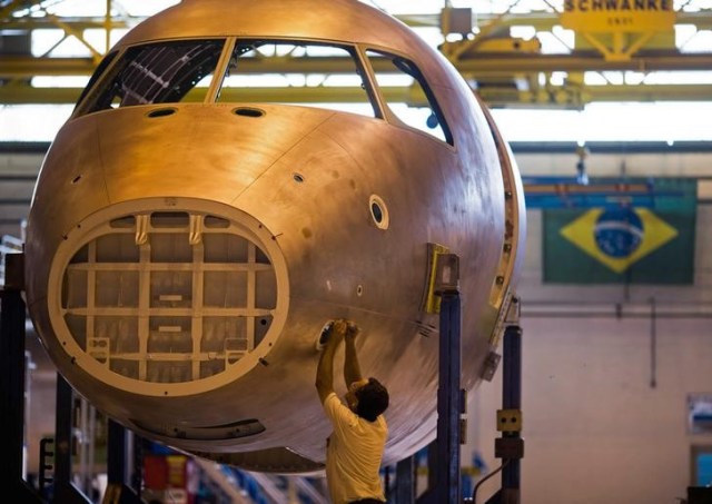 Un técnico trabaja en un avión en la línea de ensamblaje de Embraer, en Sao José dos Campos, 16 de octubre de 2014. La producción manufacturera de Brasil disminuyó a su tasa más lenta en 18 meses en julio, mostró el lunes un sondeo privado, lo que señala que la crisis en el sector está cediendo pero sigue lejos de haber terminado. REUTERS/Roosevelt Cassio