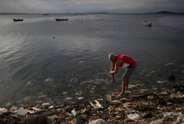 Un hombre se limpia en las aguas contaminadas de la Bahía Guanabara en Río de Janeiro, Brasil, el sábado 30 de julio de 2016. Aunque las autoridades locales, entre ellas el alcalde de Río, Eduardo Paes, han reconocido el fracaso de la ciudad en sus acciones de saneamiento de las aguas en la ciudad, lo que han calificado como una "oportunidad perdida" y una "vergüenza", las autoridades olímpicas continúan insistiendo en que los cuerpos de agua de Río serán seguros para los deportistas y los visitantes. (AP Foto/Felipe Dana)