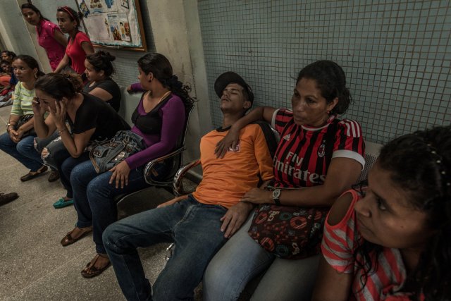 Maribel Supero sostiene a su hijo, un minero ilegal que llevaba 21 días enfermo de malaria. Credit Meridith Kohut para The New York Times