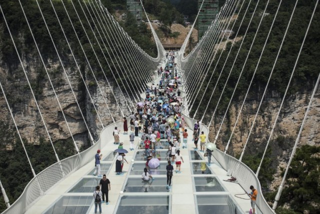 The world's highest and longest glass-bottomed bridge is seen above a valley in Zhangjiajie in China's Hunan Province on August 20, 2016. / AFP PHOTO / FRED DUFOUR