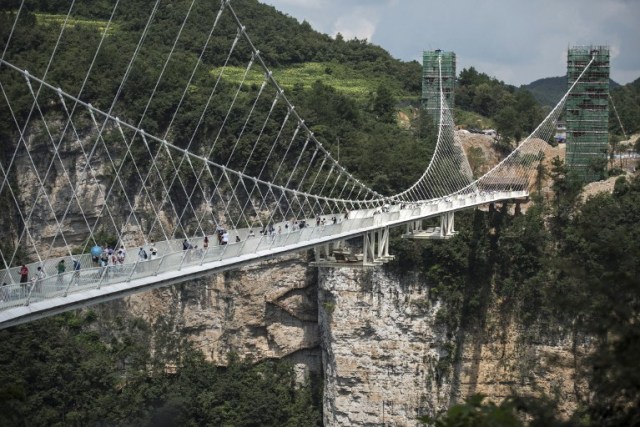 The world's highest and longest glass-bottomed bridge is seen above a valley in Zhangjiajie in China's Hunan Province on August 20, 2016. / AFP PHOTO / FRED DUFOUR