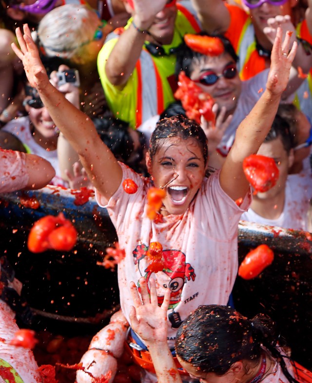 Un grupo de personas se lanza tomates durante la fiesta anual dedicada a este producto, conocida como"Tomatina", en la localidad de Buñol, a 50 kms de Valencia, en España, el 31 de agosto de 2016. Las calles de la localidad levantina se tiñen de rojo con la pulpa del tomate mientras miles de personas se lanzan frutas maduras. Camiones vertieron 160 toneladas de tomates que hicieron las delicias de unos 20.000 participantes, la mayoría extranjeros. (AP Foto/Alberto Saiz)