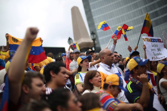 Venezuelans living in Mexico take part in a protest to demand a referendum to remove Venezuela's President Nicolas Maduro at Angel de la Independencia monument in Mexico City, Mexico, September 4, 2016. The sign reads, "Venezuela. Far, but not absent. #I revoke". REUTERS/Edgard Garrido