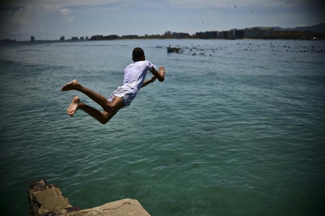 Youngsters dive in a beach of Pampatar, Margarita Island during the Non-Aligned Movement (NAM) summit, on September 15, 2016. / AFP PHOTO / RONALDO SCHEMIDT