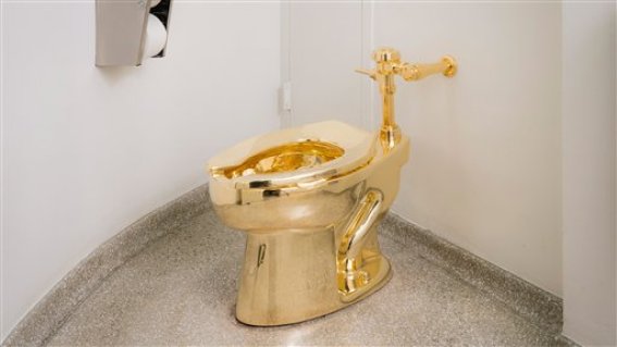 En esta fotografía sin fecha proporcionada por el museo Solomon R. Guggenheim puede apreciarse un retrete de oro de 18 quilates en el baño del cuarto piso del museo en Nueva York. Como parte de la exposición "Estados Unidos" presentada por el museo, el artista italiano Maurizio Cattelan reemplazó el inodoro estándar con la réplica totalmente funcional fundida en oro. (Kristopher McKay/Museo Solomon R. Guggenheim vía AP)