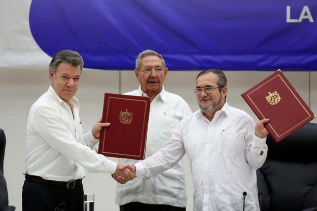 Foto de archivo del presidente de Colombia, Juan Manuel Santos (I) y el líder de las FARC, Rodrigo Londoño (D), tras firmar el acuerdo de paz, junto al mandatario cubano Raúl Castro, en La Habana. Jun 23, 2016. Una bala de ametralladora convertida en bolígrafo, símbolo del cambio en Colombia, será usada el lunes por el presidente Juan Manuel Santos y el máximo líder de las FARC, Rodrigo Londoño, para firmar el histórico acuerdo de paz que busca acabar con el conflicto armado más extenso de América Latina. REUTERS/Alexandre Meneghini