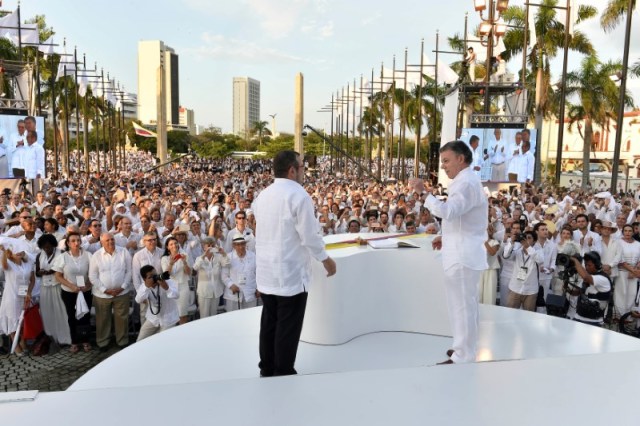 El presidente de Colombia, Juan Manuel Santos, y el líder de las FARC, Rodrigo Londoño, alias Timochenko, tras firmar el acuerdo de paz, en Cartagena. 26 de septiembre de 2016. Los colombianos acudirán a las urnas el domingo para decidir en un plebiscito si apoyan o rechazan los acuerdos de paz que firmó el Gobierno del presidente Juan Manuel Santos con la guerrilla de las Fuerzas Armadas Revolucionarias de Colombia (FARC) para poner fin a un violento conflicto de más de cinco décadas. Colombian Presidency/Handout via Reuters/File Photo