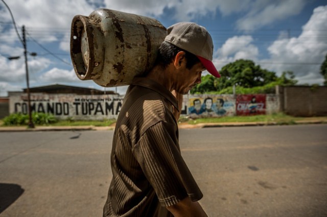  Cerca de los pozos donde se quema el petróleo, la gente hace fila por gas licuado. PHOTO: MIGUEL GUTIÉRREZ PARA THE WALL STREET JOURNAL