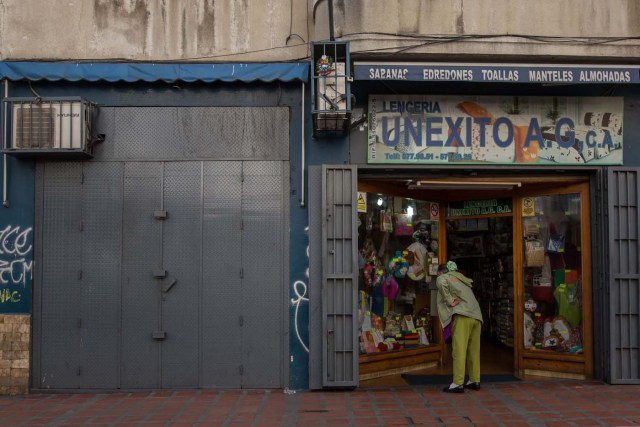 CAR01. CARACAS (VENEZUELA), 28/10/2016.- Un local comercial abierto y otro cerrado vistos hoy, viernes 28 de octubre de 2016, en Caracas (Venezuela). El paro general de 12 horas convocado por la oposición venezolana se cumple a medias en el país pues tanto las entidades bancarias como algunos comercios y oficinas abrieron sus puertas, sin embargo, las principales vías se mostraron con mucho menos tráfico que el que se observa en un día laboral normal. EFE/MIGUEL GUTIÈRREZ