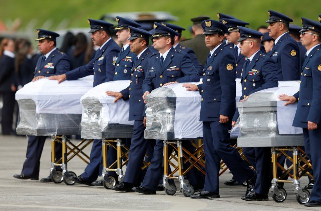 Military personnel unload a coffin with the remains of Brazilian victims who died in an accident of the plane that crashed into the Colombian jungle with Brazilian soccer team Chapecoense, at the airport from where the bodies will be flown home to Brazil, in Medellin, Colombia December 2, 2016. REUTERS/Jaime Saldarriaga TPX IMAGES OF THE DAY