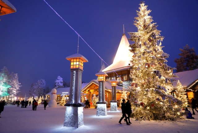 Visitors stand outside Santa Claus' office at Santa Claus' Village on the Arctic Circle near Rovaniemi, Finland, December 15, 2016. REUTERS/Pawel Kopczynski SEARCH "KOPCZYNSKI SANTA" FOR THIS STORY. SEARCH "THE WIDER IMAGE" FOR ALL STORIES