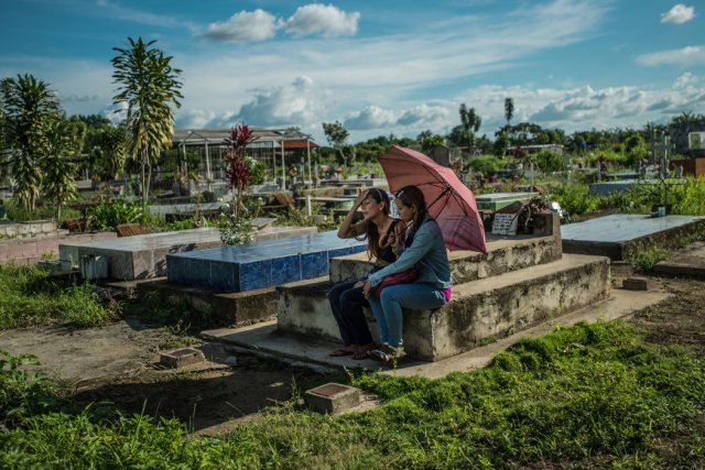 Yamilet Lugo, a la izquierda, visitó en septiembre la tumba de su hijo Kevin Lara Lugo, quien falleció en julio cuando cumplía 16 años. La familia pasó tres días sin comer y el joven se enfermó después de ingerir la yuca que consiguió en un campo abandonado. Credit Meridith Kohut para The New York Times