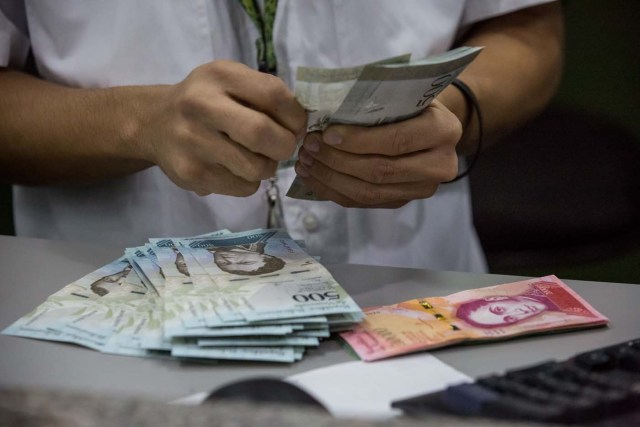 A bank employee's hands new bills of the Venezuelan currency in a bank, in Caracas, Venezuela, 16 January 2017. The new bills of 500, 5.000 and 20.000 bolivares, three of the six new Venezuelan bills start to run in the country, as it was announced by President Nicolas Maduro on 15 January 2017. EPA/Miguel Gutierrez