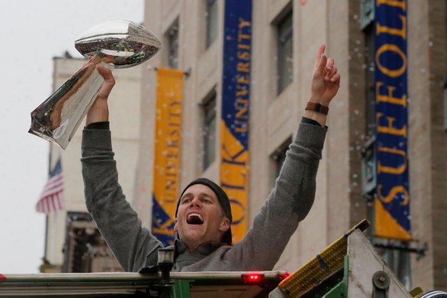 New England Patriots quarterback Tom Brady holds up one of the team's five Vince Lombardi trophies during their victory parade through the streets of Boston after winning Super Bowl LI, in Boston