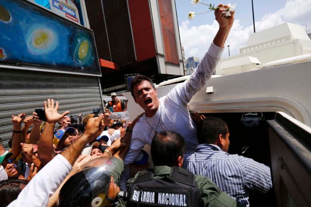 Venezuelan opposition leader Leopoldo Lopez gets into a National Guard armored vehicle in Caracas February 18, 2014. Lopez, wanted on charges of fomenting deadly violence, handed himself over to security forces on Tuesday, Reuters witnesses said. Lopez, a 42-year-old U.S.-educated economist who has spearheaded a recent wave of protests in Venezuela, got into an armored vehicle after giving a speech to an opposition rally in Caracas. REUTERS/Jorge Silva (VENEZUELA - Tags: POLITICS CIVIL UNREST)