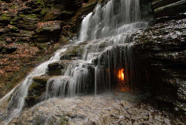 Eternal Flame Falls, Nueva York, Estados Unidos En la Shale Creek Preserve en el parque Chestnut Ridge Park, están las cataratas Eternal Flame Falls, famosas por sus brillantes llamas doradas detrás de una cortina de agua. El fuego se debe a un escape de gas natural dentro de una pequeña cueva detrás de la catarata. Si bien la llama está casi siempre encendida, puede apagarse y volverse a encender.