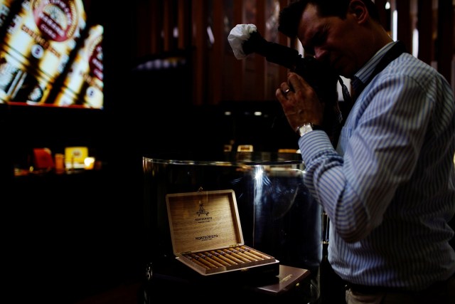 A photographer takes a photograph of cigars on display at the 19th Habanos Festival in Havana, Cuba, February 27, 2017. REUTERS/Alexandre Meneghini