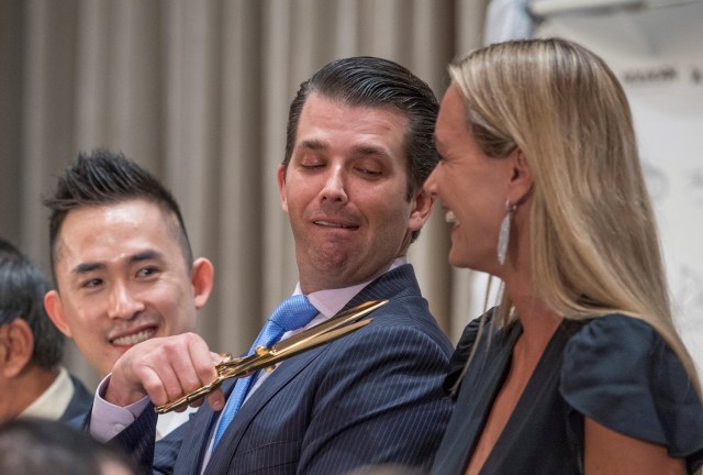 REFILE - CORRECTING NAME SPELLING Donald Trump Jr. (C) jokes around and motions with a large pair of scissors toward the throat of his wife Vanessa Trump (R) while Joo Kim Tiah (L) the CEO of TA Global, the owner and developer of Trump International Hotel and Tower Vancouver, looks on during the grand opening of the Trump International Hotel and Tower in Vancouver, British Columbia, Canada February 28, 2017. REUTERS/Nick Didlick TPX IMAGES OF THE DAY