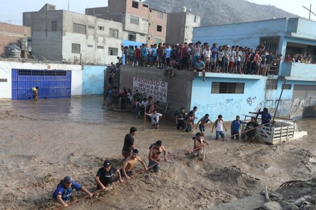 Gente atrapada en un techo es rescatada por la policía tras inundaciones y deslaves, distrito de Huachipa en Lima. 17 de marzo de 2017. La mitad de Perú se encuentra en estado de emergencia por el desborde de ríos y aludes de lodo y piedras que han destruido carreteras, puentes y arrastrado personas y animales, en un inesperado fenómeno climático de "El Niño Costero" que se prolongaría hasta abril. REUTERS/Guadalupe Pardo