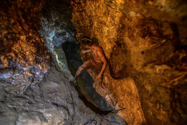 Ender Moreno looks for gold at La Culebra gold mine in El Callao, Bolivar state, southeastern Venezuela on March 1, 2017. Although life in the mines of eastern Venezuela is hard and dangerous, tens of thousands from all over the country head for the mines daily in overcrowded trucks, pushed by the rise in gold prices and by the severe economic crisis affecting the country, aggravated recently by the drop in oil prices. / AFP PHOTO / JUAN BARRETO / TO GO WITH AFP STORY by Maria Isabel SANCHEZ