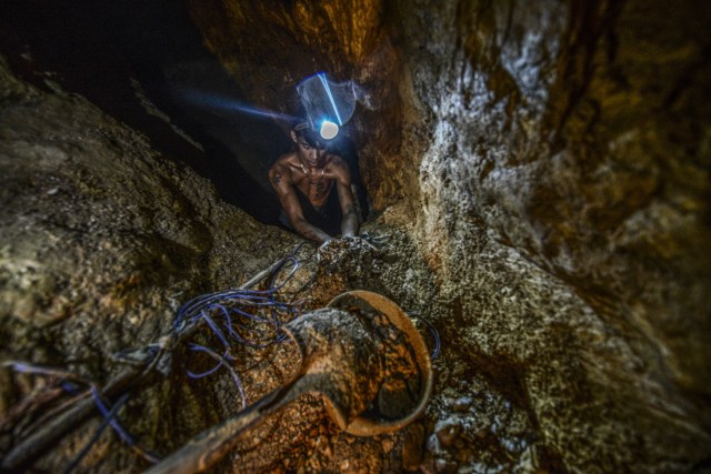 Ender Moreno shows stones laced with gold at La Culebra gold mine in El Callao, Bolivar state, southeastern Venezuela on March 1, 2017. Although life in the mines of eastern Venezuela is hard and dangerous, tens of thousands from all over the country head for the mines daily in overcrowded trucks, pushed by the rise in gold prices and by the severe economic crisis affecting the country, aggravated recently by the drop in oil prices. / AFP PHOTO / JUAN BARRETO