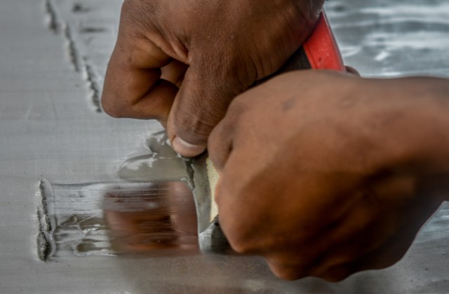 A worker scrapes gold-mercury amalgam from an aluminium sheet at a gold mine in El Callao, Bolivar state, southeastern Venezuela on February 25, 2017. Although life in the mines of eastern Venezuela is hard and dangerous, tens of thousands from all over the country head for the mines daily in overcrowded trucks, pushed by the rise in gold prices and by the severe economic crisis affecting the country, aggravated recently by the drop in oil prices. / AFP PHOTO / JUAN BARRETO / TO GO WITH AFP STORY by Maria Isabel SANCHEZ