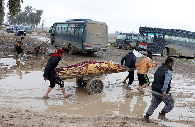 Familiares cargando los cuerpos de los muertos en ataques aéreos en Mosul