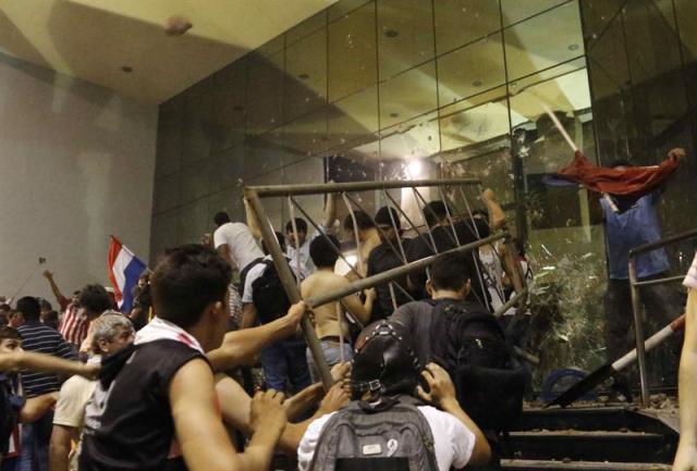 Manifestantes atacan hoy, viernes 31 de marzo de 2017, la sede del Congreso Nacional en Asunción (Paraguay). EFE