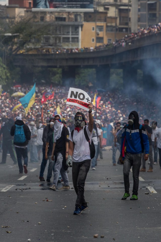 CAR01. CARACAS (VENEZUELA), 06/04/2017 - Un grupo de personas participa en una manifestación de opositores al gobierno de Nicolás Maduro hoy, jueves 6 de abril de 2017, en Caracas (Venezuela). La Policía Nacional Bolivariana (PNB) dispersó hoy con gases lacrimógenos y agua una marcha opositora en Caracas que pretendía llegar hasta la Defensoría del Pueblo para pedir su respaldo al proceso iniciado por el Parlamento contra siete magistrados del Tribunal Supremo de Justicia (TSJ). EFE/MIGUEL GUTIERREZ