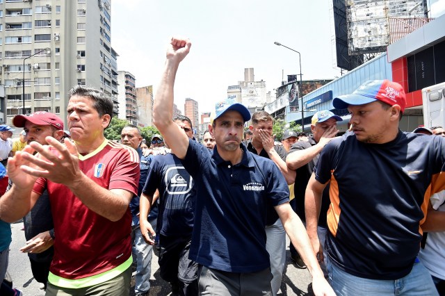 Opposition leader Henrique Capriles(C) is seen during a demonstration against Nicolas Maduro's government east of Caracas on April 8, 2017. Venezuelan authorities on Friday banned a top opposition leader from public office for 15 years, the latest move in an increasingly tense power struggle in the crisis-hit country. Henrique Capriles was one of the leaders of mass demonstrations this week against socialist President Nicolas Maduro that led to clashes with police / AFP PHOTO / JUAN BARRETO