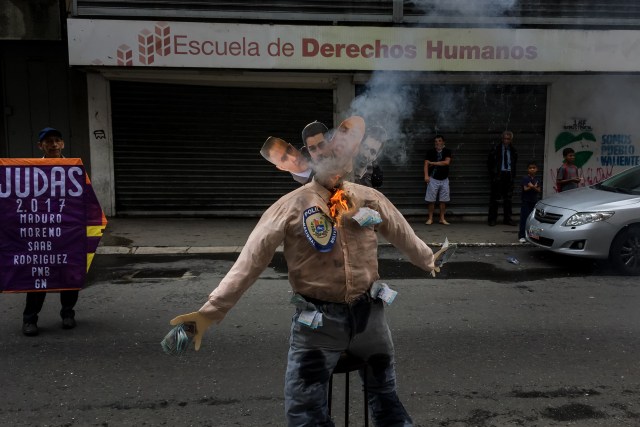 CAR03. CARACAS (VENEZUELA), 16/04/2017.- Fotografía de un muñeco quemándose con fotografías del defensor del pueblo de Venezuela, Tarek Wiliam Saab, el presidente de Venezuela, Nicolás Maduro, el alcalde del municipio Libertador de Caracas, Jorge Rodríguez y al presidente del Tribunal Supremo de Justicia Mikel Moreno durante la "Quema de Judas" hoy, domingo 16 de abril de 2017, en el marco de la Semana Santa en Caracas (Venezuela). EFE/MIGUEL GUTIÉRREZ