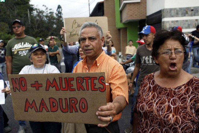 People holding a placard that reads "No more deaths, Maduro" gather outside the wake of Paola Ramirez, a student who died during a protest, in San Cristobal, Venezuela, April 20, 2017. REUTERS/Carlos Eduardo Ramirez