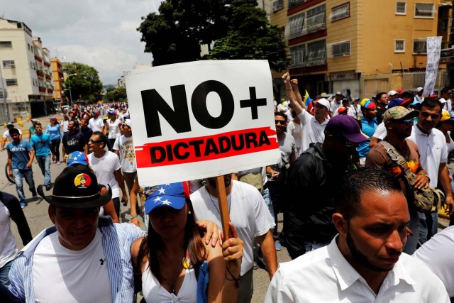 Demonstrators take part in a rally to honor the victims of violence during the protests and against Venezuela's President Nicolas Maduro's government in Caracas, Venezuela, April 22, 2017. Placard reads "No more dictatorship" REUTERS/Carlos Garcia Rawlins