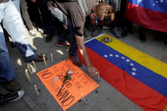 A student lights up a candle as he takes part in a tribute to Juan Pablo Pernalete, who died after being hit by a tear gas shot during a protest against Venezuelan President Nicolas Maduro, in Caracas, Venezuela April 27, 2017. REUTERS/Marco Bello