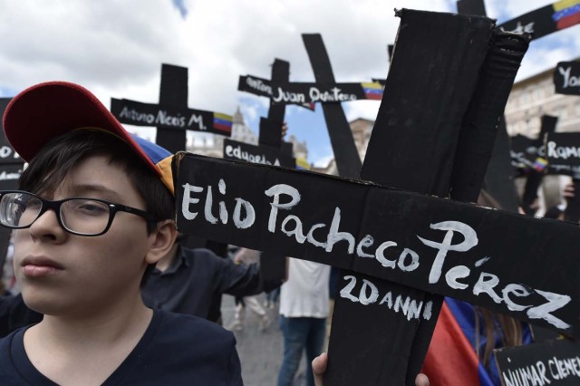 Members of the Venezuelian community hold black crosses with names of victims of clashes with police during protests against Venezuela's President Nicolas Maduro, on May 7, 2017  at St Peter's square before the Regina Coeli prayer of Pope Francis in Vatican. Pope Francis last week made a heartfelt appeal for "negotiated solutions" to end the violence in crisis-torn Venezuela for the sake of an "exhausted population".  The death toll since April -- when the protests intensified after Maduro's administration and the courts stepped up efforts to undermine the opposition -- is at least 36, according to prosecutors, with hundreds more injured. / AFP PHOTO / TIZIANA FABI