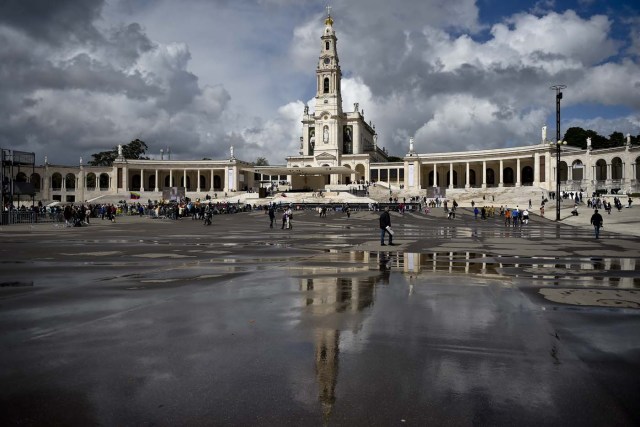 "Nossa Senhora do Rosario de Fatima" basilica reflects on the wet ground at Fatima shrine, central Portugal, on May 11, 2017.  Two of the three child shepherds who reported apparitions of the Virgin Mary in Fatima, Portugal, one century ago, will be declared saints on May 13, 2017 by Pope Francis. The canonisation of Jacinta and Francisco Marto will take place during the Argentinian pontiff's visit to a Catholic shrine visited by millions of pilgrims every year. / AFP PHOTO / PATRICIA DE MELO MOREIRA