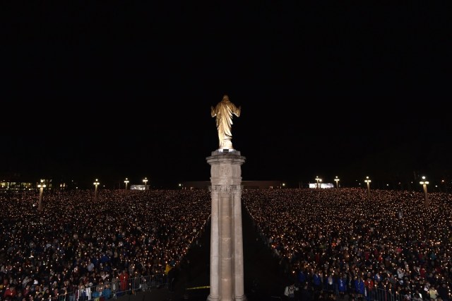 Pilgrims hold candles at the Shrine of Fatima during the Blessing for the Candles from the Chapel of the Apparitions by Pope Francis, in Fatima on May 12, 2017. Two of the three child shepherds who reported apparitions of the Virgin Mary in Fatima, Portugal, one century ago, will be declared saints on May 13, 2017 by Pope Francis. The canonisation of Jacinta and Francisco Marto will take place during the Argentinian pontiff's visit to a Catholic shrine visited by millions of pilgrims every year. / AFP PHOTO / TIZIANA FABI